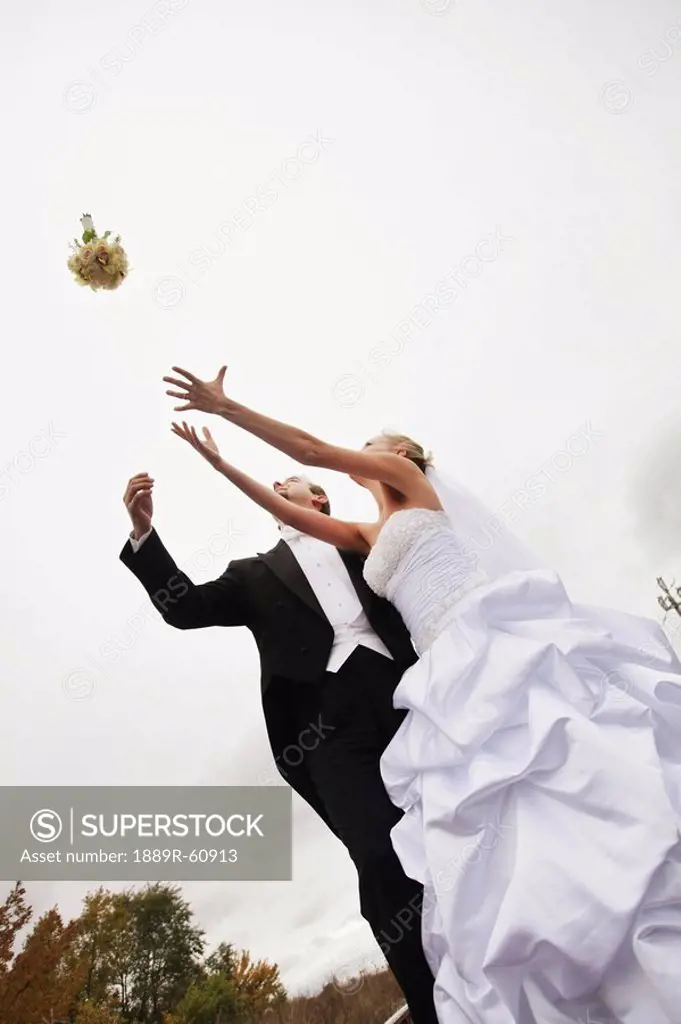 Stoney Creek, Ontario, Canada, A Bride And Groom Trying To Catch A Bouquet
