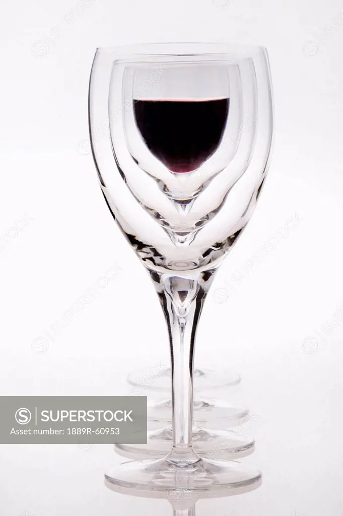 A Row Of Wine Glasses With Red Wine In The Last Glass