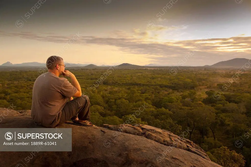 A Young Man Sitting On A Rock And Looking At The Landscape, Manica, Mozambique, Africa