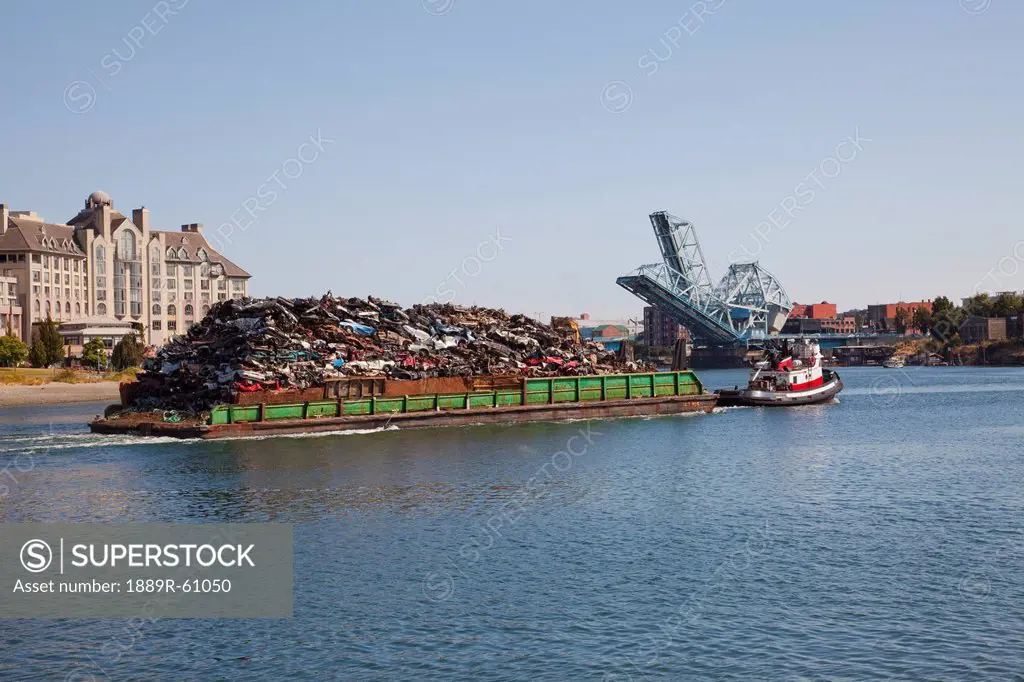 A Barge Full Of Crushed Vehicles Being Pulled In The Water, Langley, British Columbia, Canada