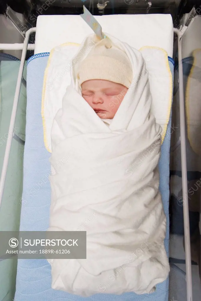 A Newborn Baby Wrapped In A Blanket Wearing A Cap In The Hospital, Millet, Alberta, Canada