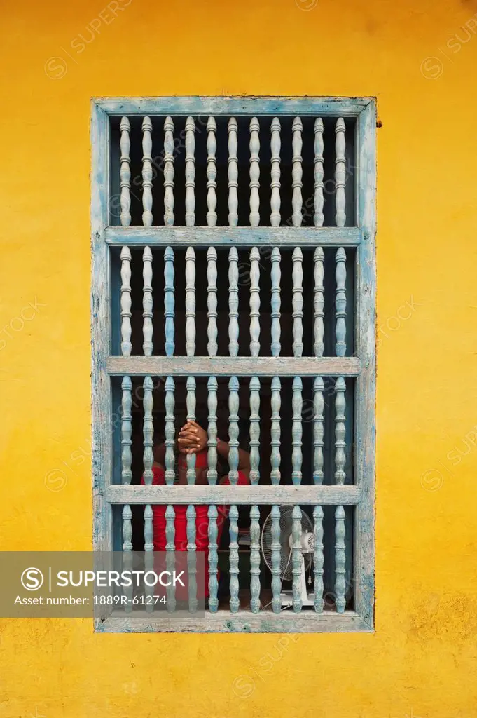 Cuban House Facade With Hands Holding The Bars In The Window, Trinidad, Cuba