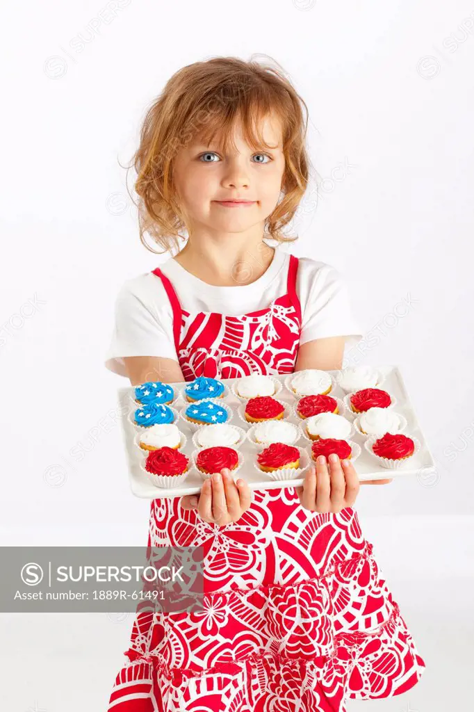 A Girl Holding A Platter Of Cupcakes