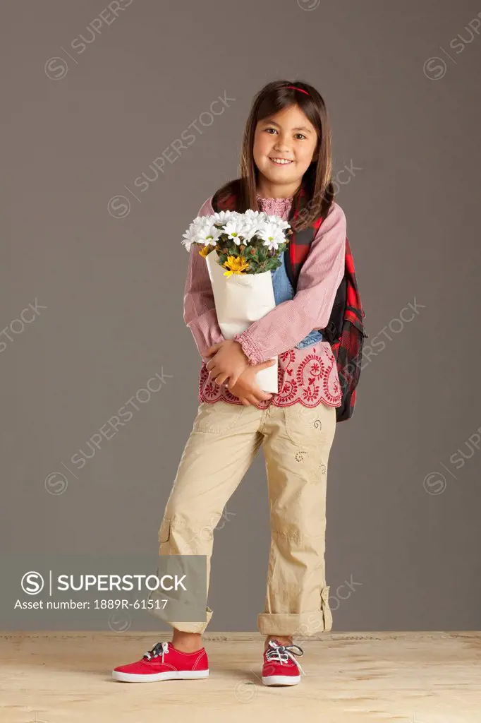 A Girl With A Backpack Holding A Bouquet Of Flowers