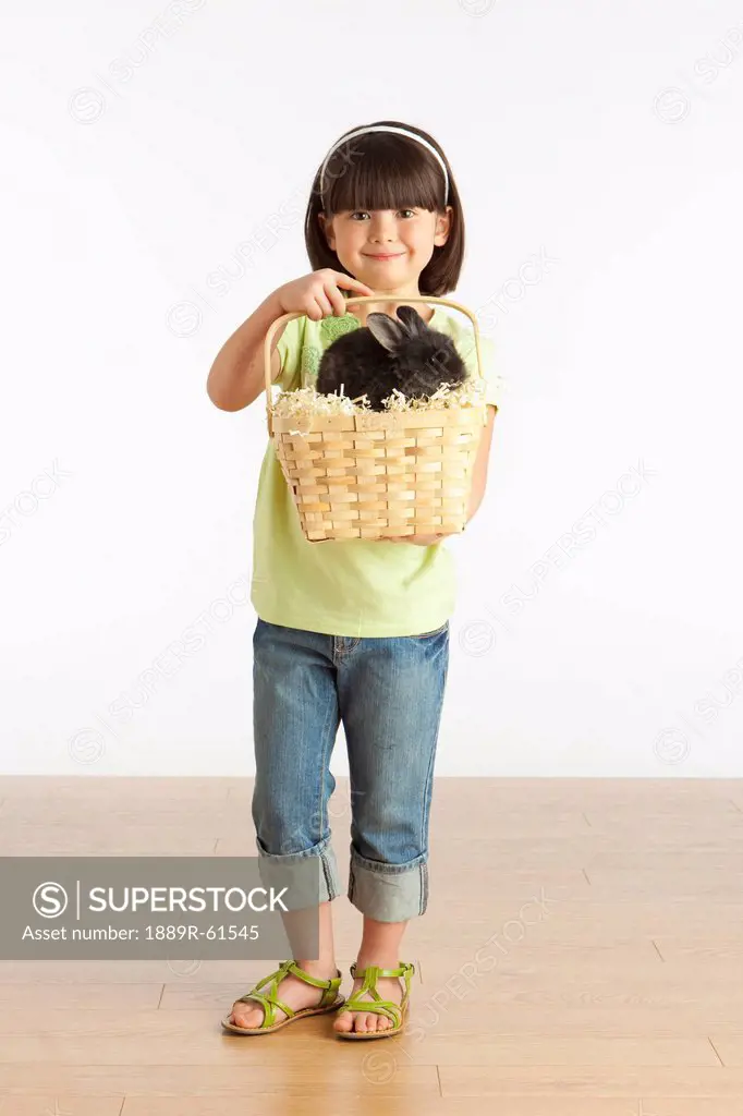 A Girl Holding A Basket With A Rabbit In It