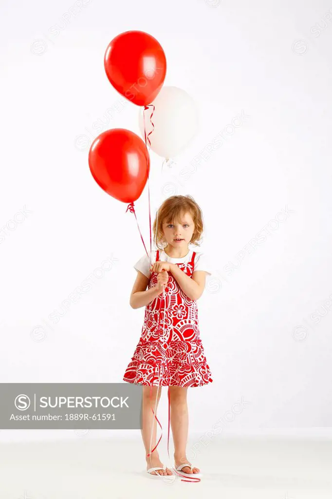A Girl Holding Two Red Balloons