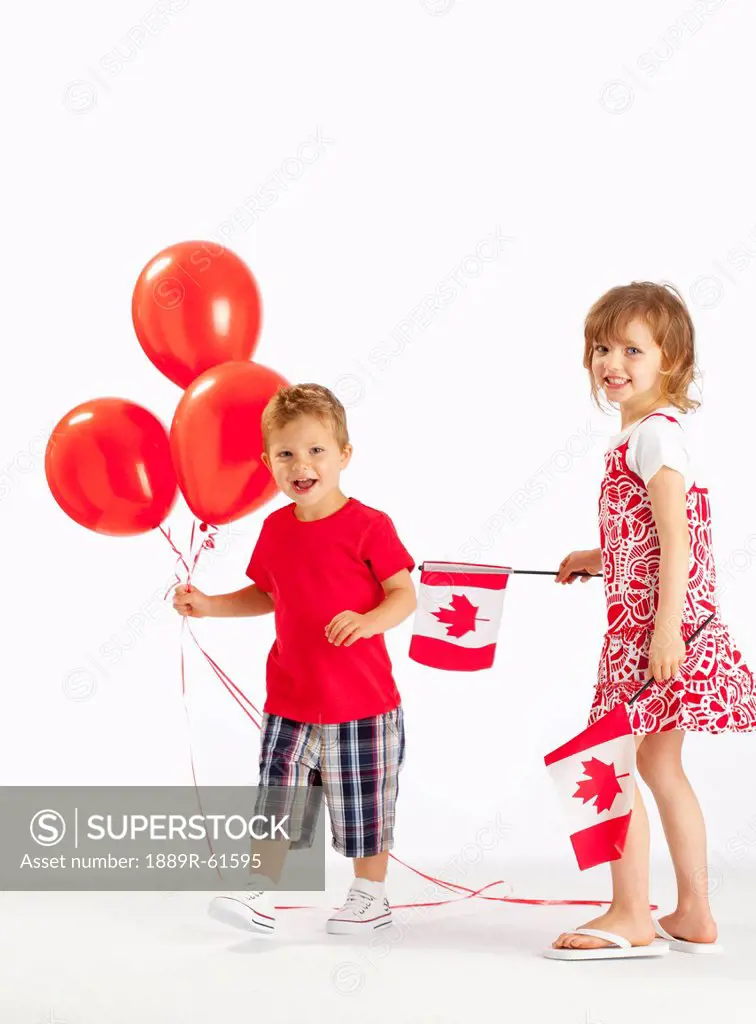 A Girl And Boy Holding Red Balloons And Canada Flags