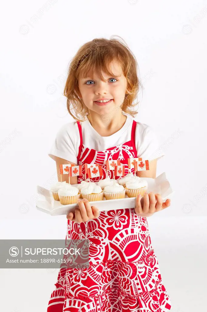 A Girl Holding A Plate Of Cupcakes