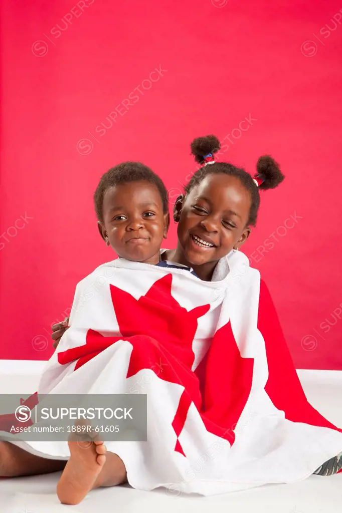 A Boy And Girl Wrapped In A Canadian Flag