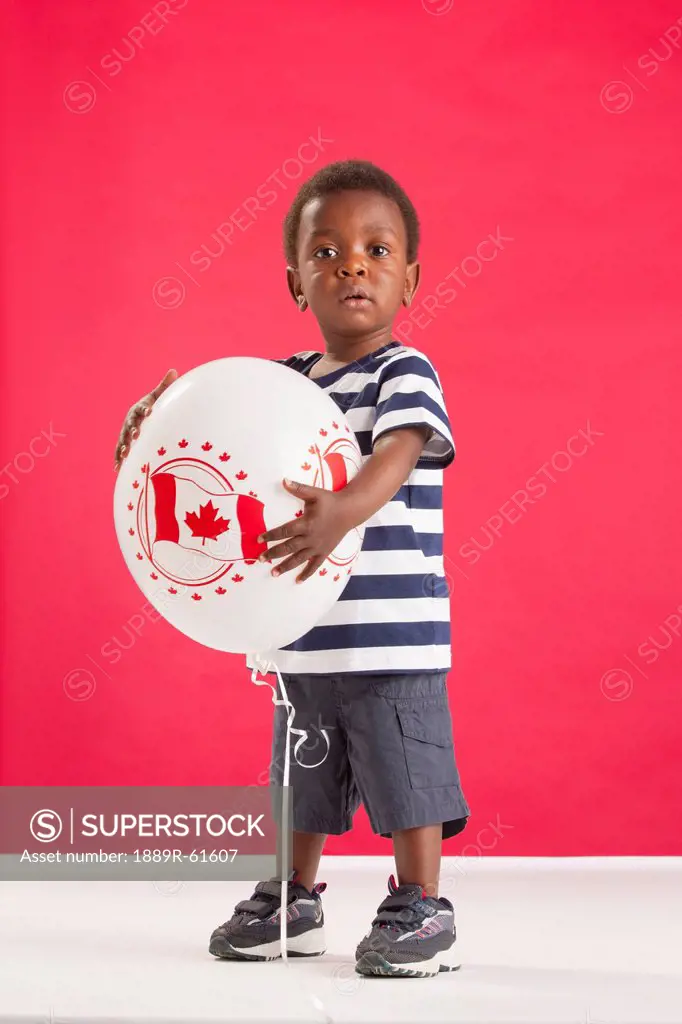 A Young Boy Holding A Balloon With A Picture Of The Canada Flag