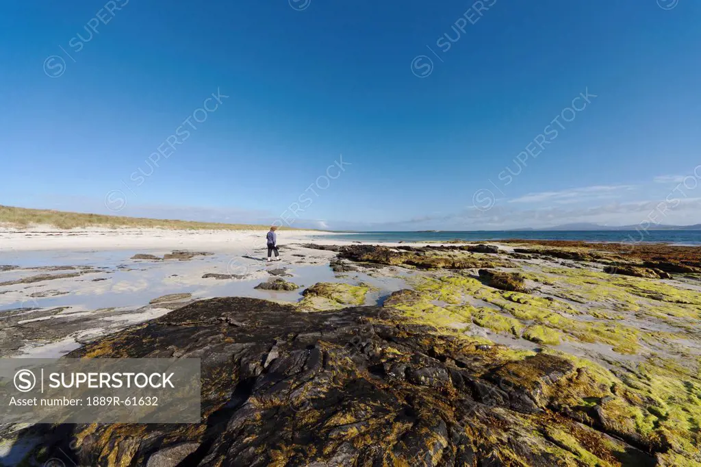 A Person Walking Along The Shore Of Eilogarry Beach, Isle Of Barra, Scotlnd
