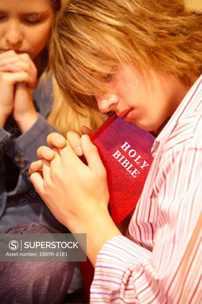 Teen holds a Bible and prays