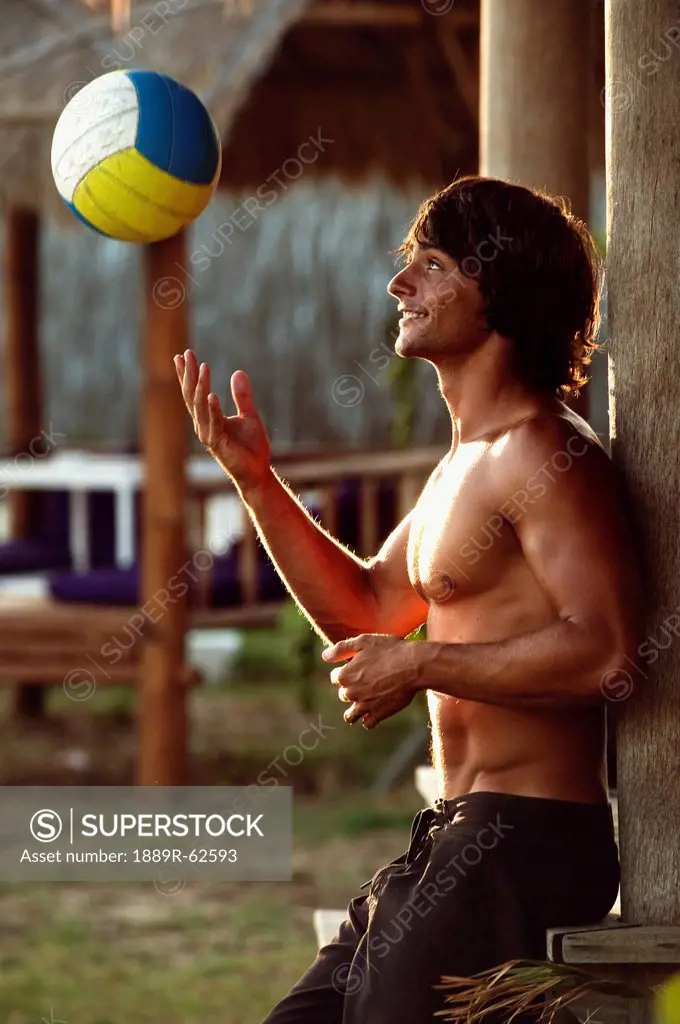 a man playing with a beach ball at explora beach bar, tarifa, cadiz, andalusia, spain