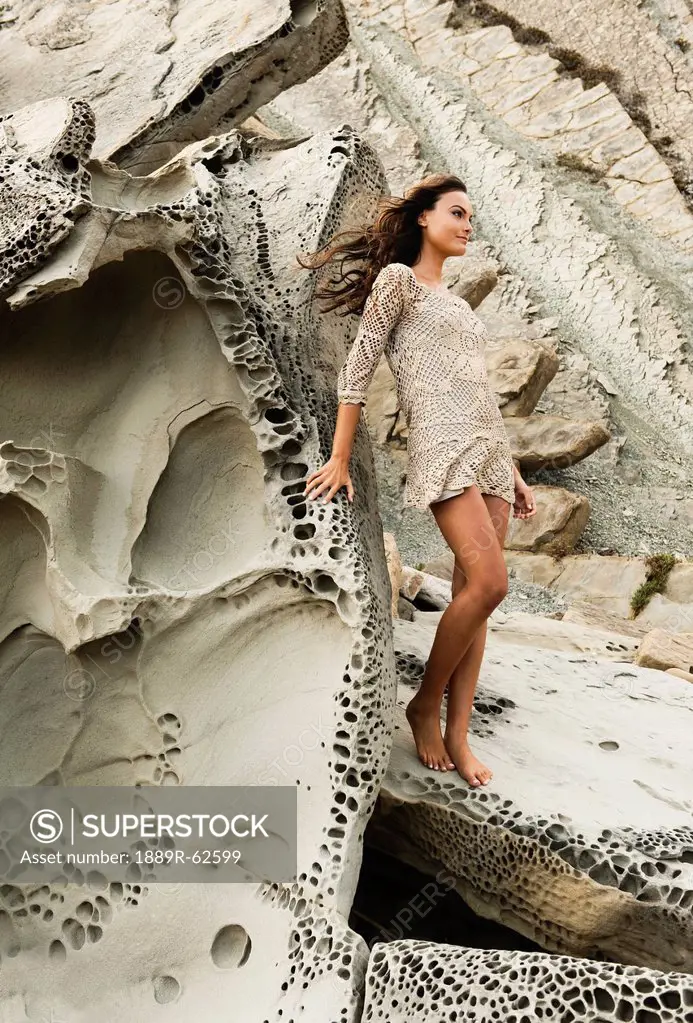 a woman posing against a rock formation in parque natural del estrecho, tarifa, cadiz, andalusia, spain