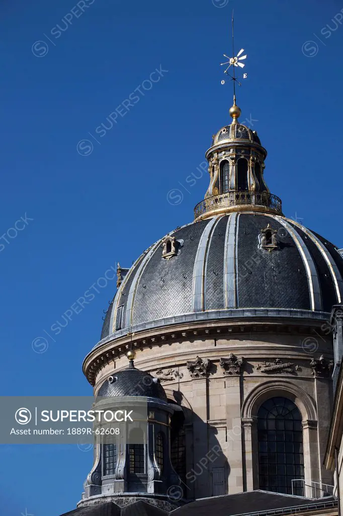 dome tower with gold trim against a blue sky, paris, france