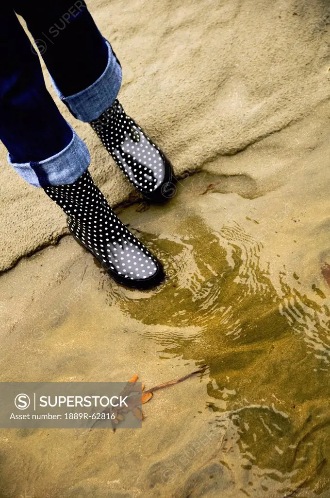 a woman´s rain boots reflected in the water, seattle, washington, united states of america
