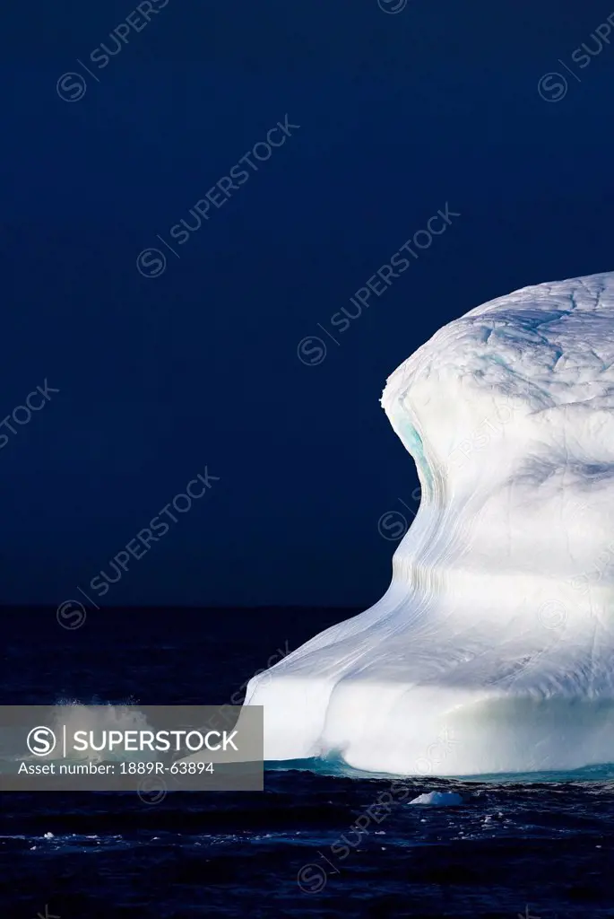 ocean water splashing against an iceberg in the high arctic waters, nunavut, canada