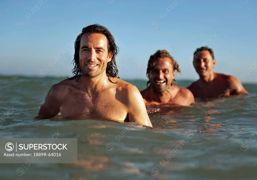 three men in the ocean, tarifa, cadiz, andalusia, spain