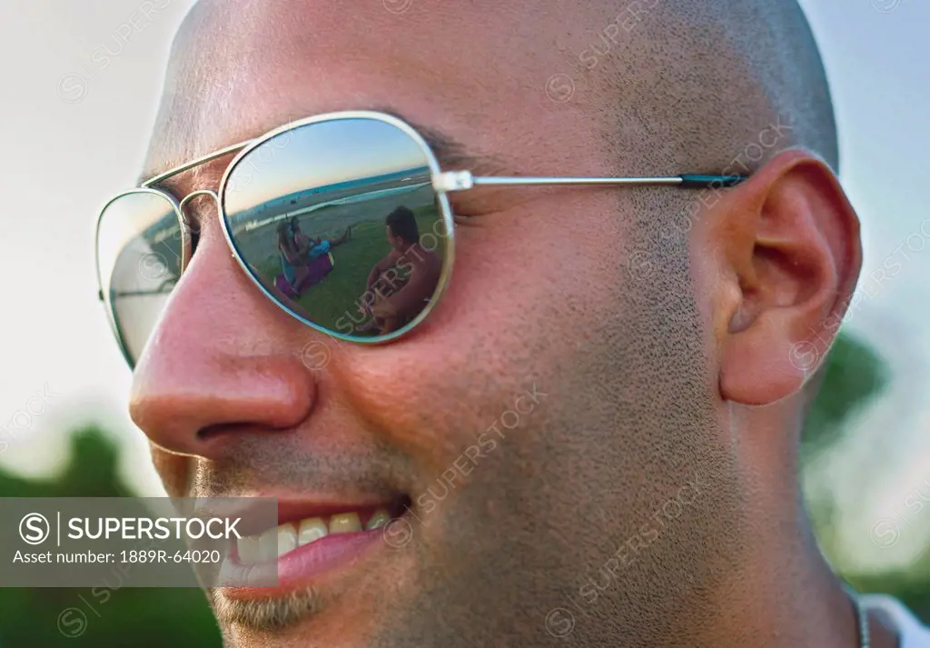 portrait of a man wearing sunglasses with a reflection of the beach and ocean, tarifa, cadiz, andalusia, spain