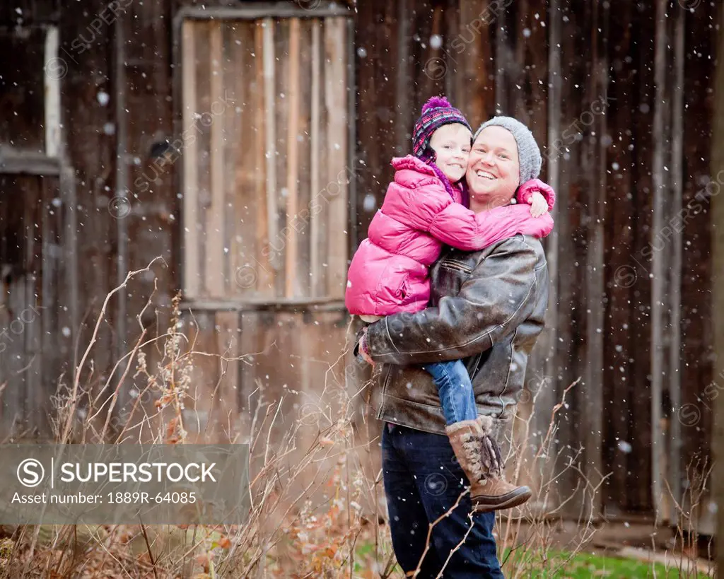 a father and daughter in a snowfall, grimsby, ontario, canada