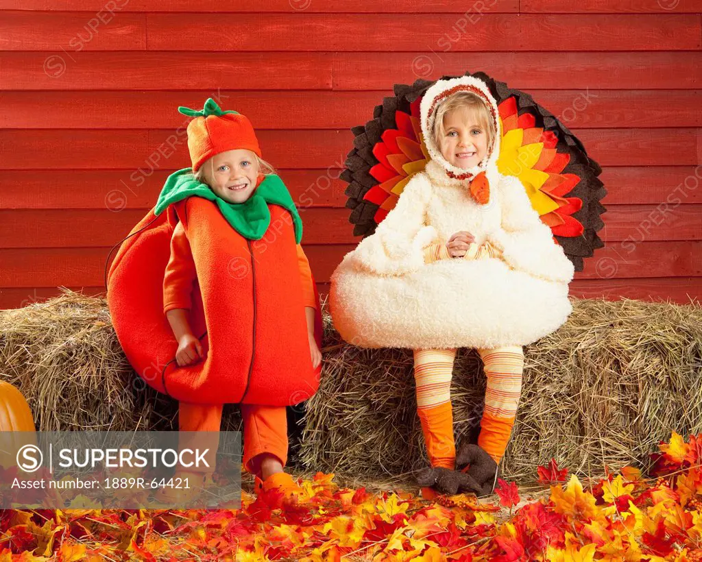 two children in costumes in autumn, three hills, alberta, canada