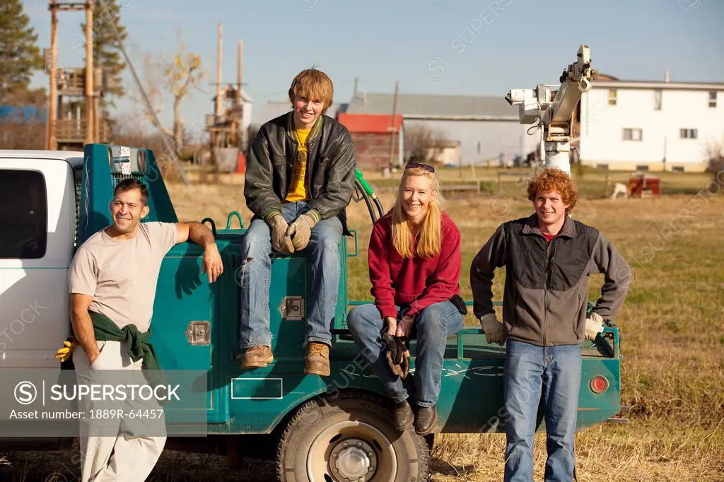 a group of people sitting on the back of a truck, three hills, alberta, canada
