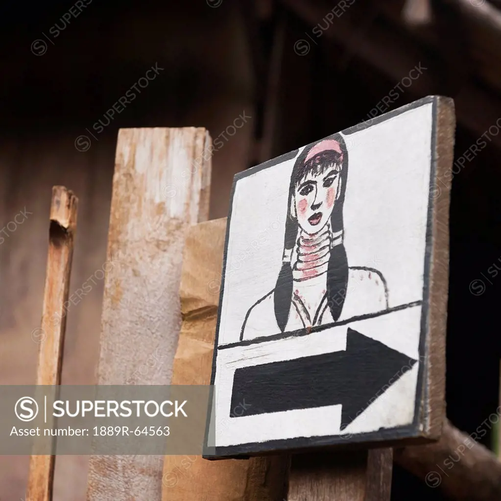 direction sign with drawing of woman, huay pu keng, thailand