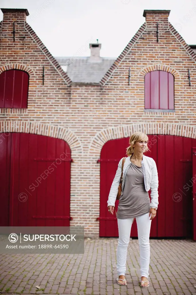 a woman standing outside a traditional dutch home, houten, the netherlands