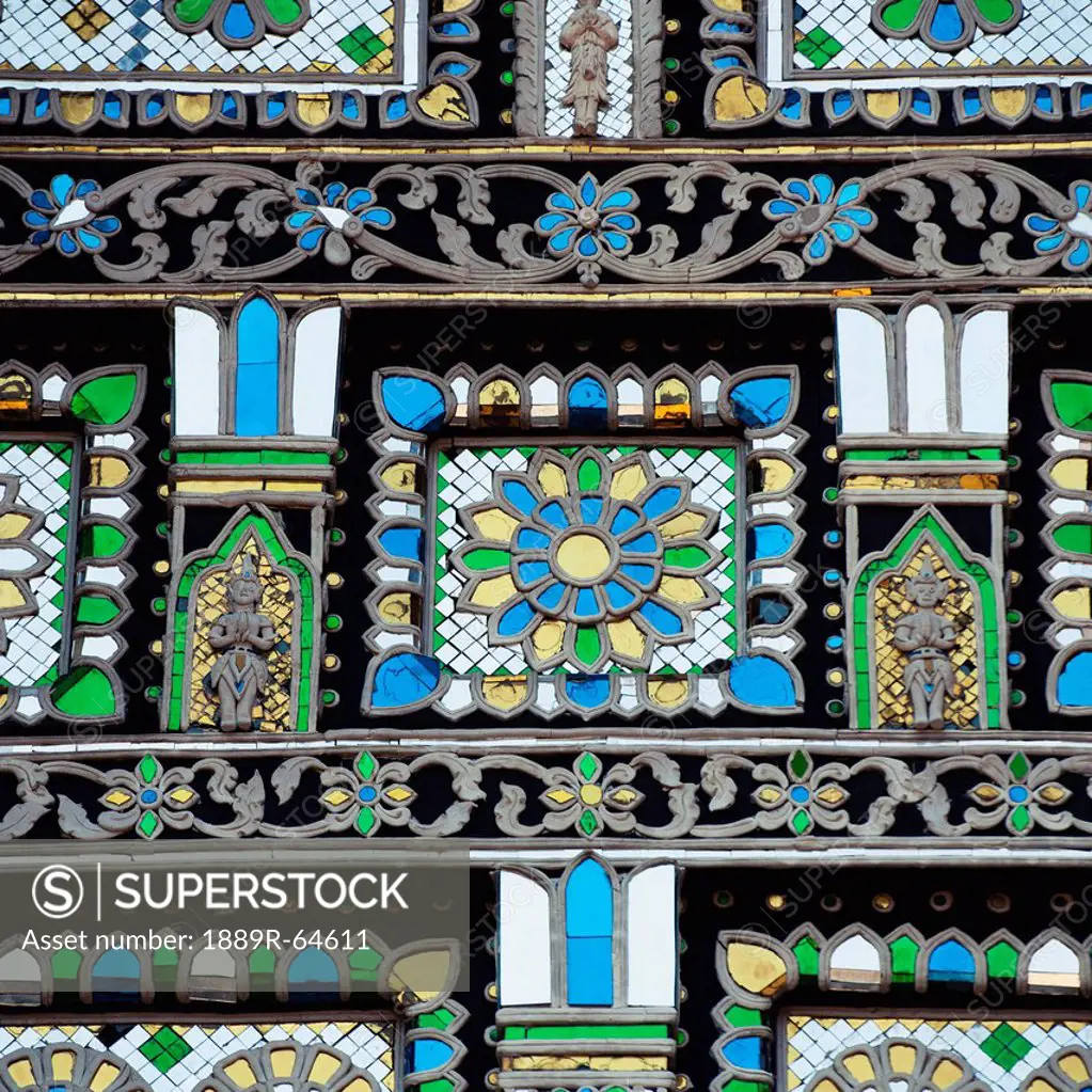 an ornate mosaic of blue, yellow, white and green stone in chedi luang temple, chiang mai, thailand