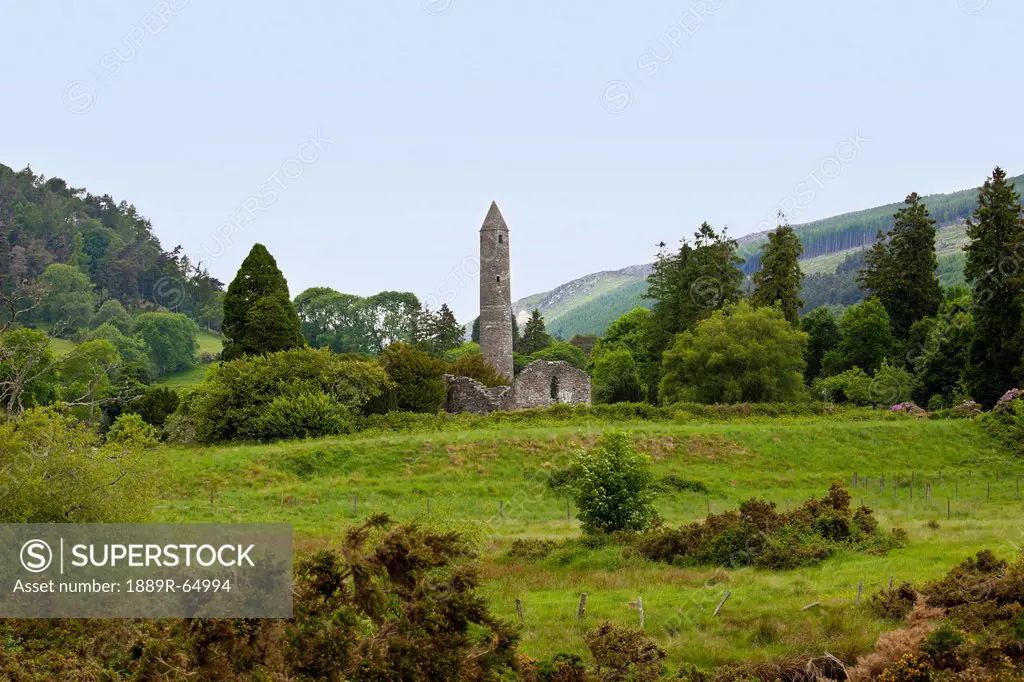 ruins of a building and a round tower on a 6th century monastic site, glendalough, county wicklow, ireland