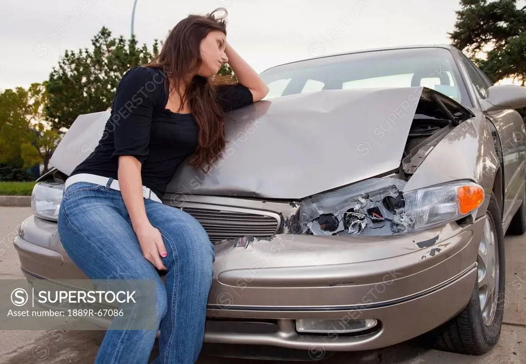 young woman with vehicle that has been in a collision, edmonton, alberta, canada