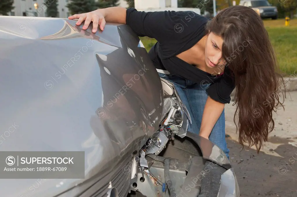 young woman with vehicle that has been in a collision, edmonton, alberta, canada