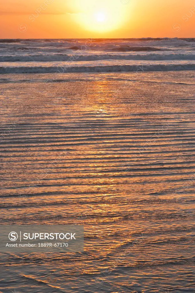 sunrise over breaking waves with water rippling over shore, florida, united states of america