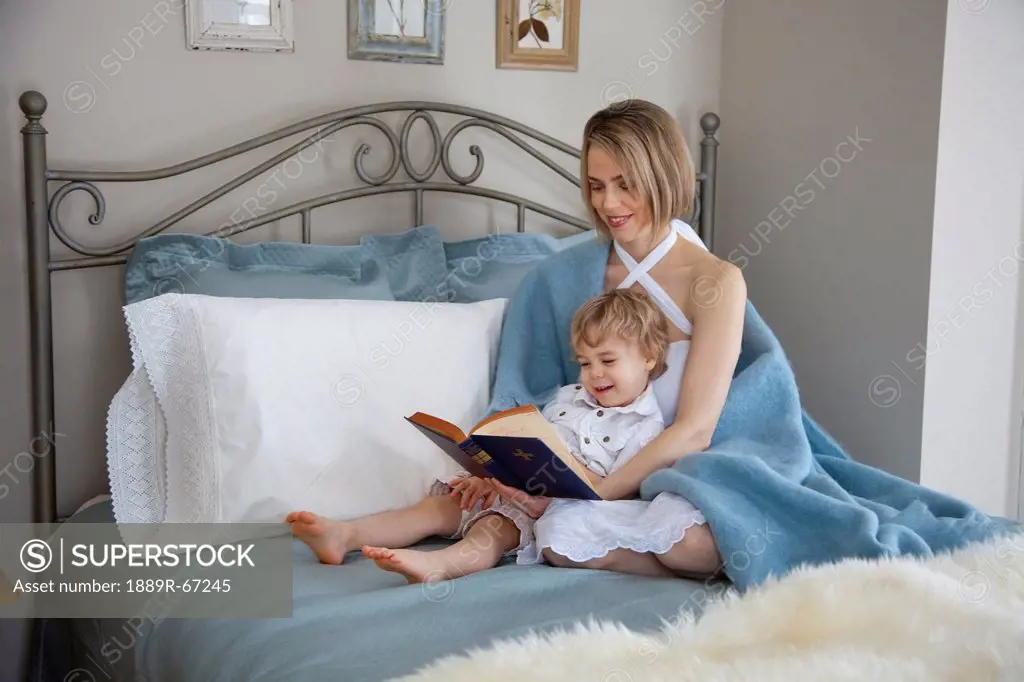 toddler and mother in bed reading, jordan, ontario, canada