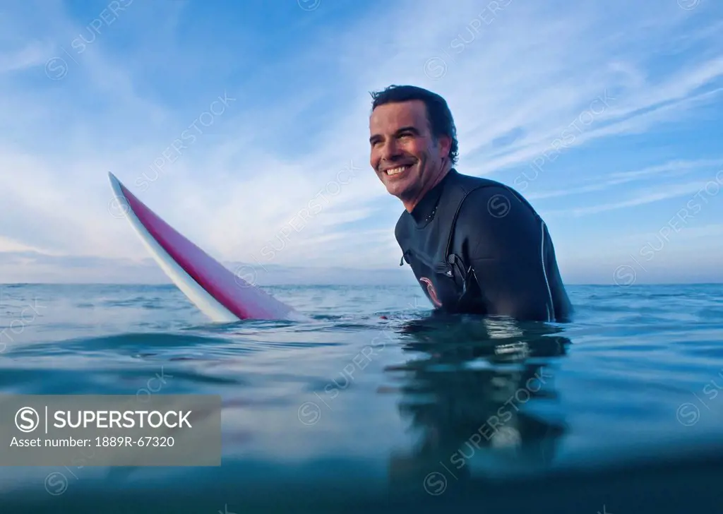a man in the water with his surfboard at bunker beach, tarifa, cadiz, andalusia, spain