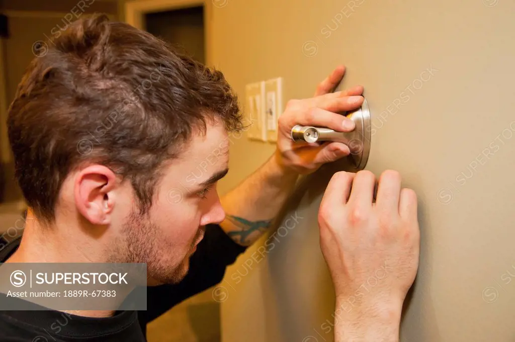 tradesman installing towel bar on wall