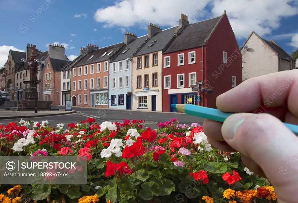 digitally enhanced image of hand holding pencil against town, jedburgh, scottish borders, scotland