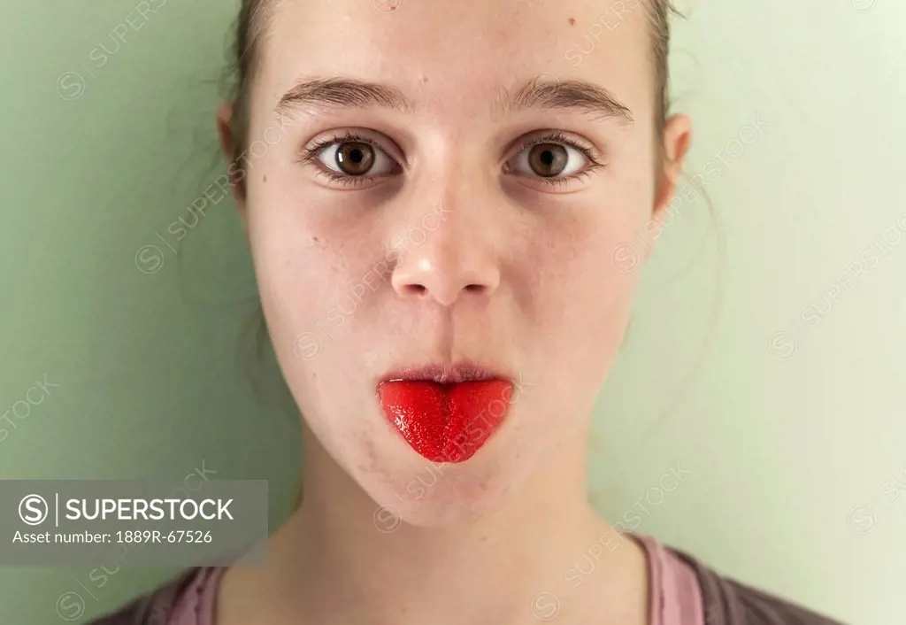 portrait of girl sticking out her bright red tongue