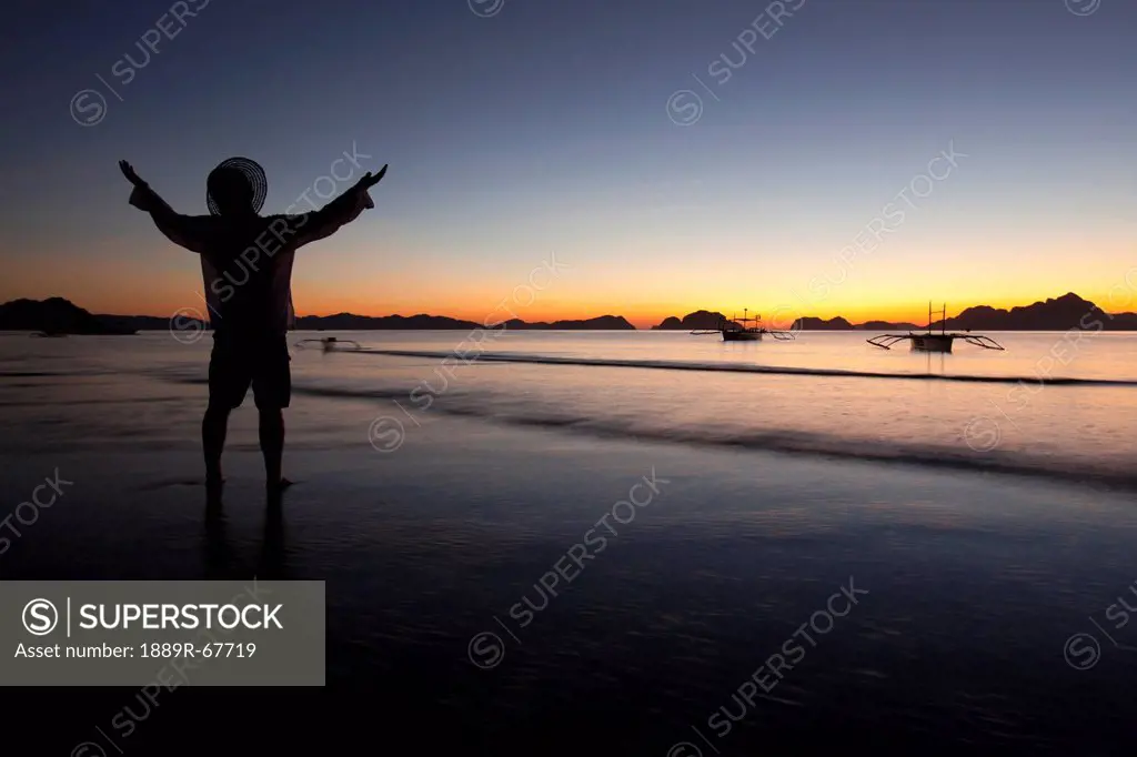 a man on a beach at sunset, corong_corong, palawan, philippines