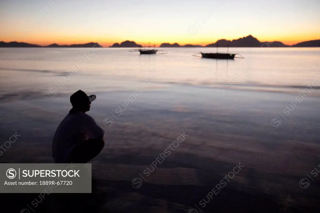 a man on a beach at sunset, corong_corong, palawan, philippines