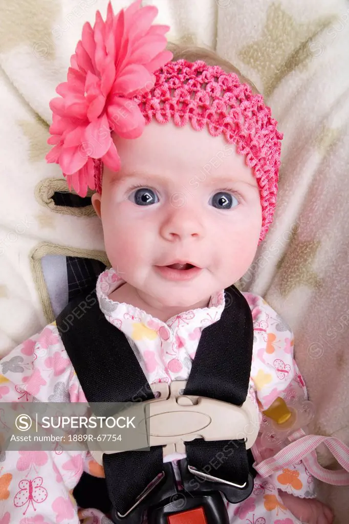 a baby girl sitting in her car seat wearing a pink hat, alberta, canada
