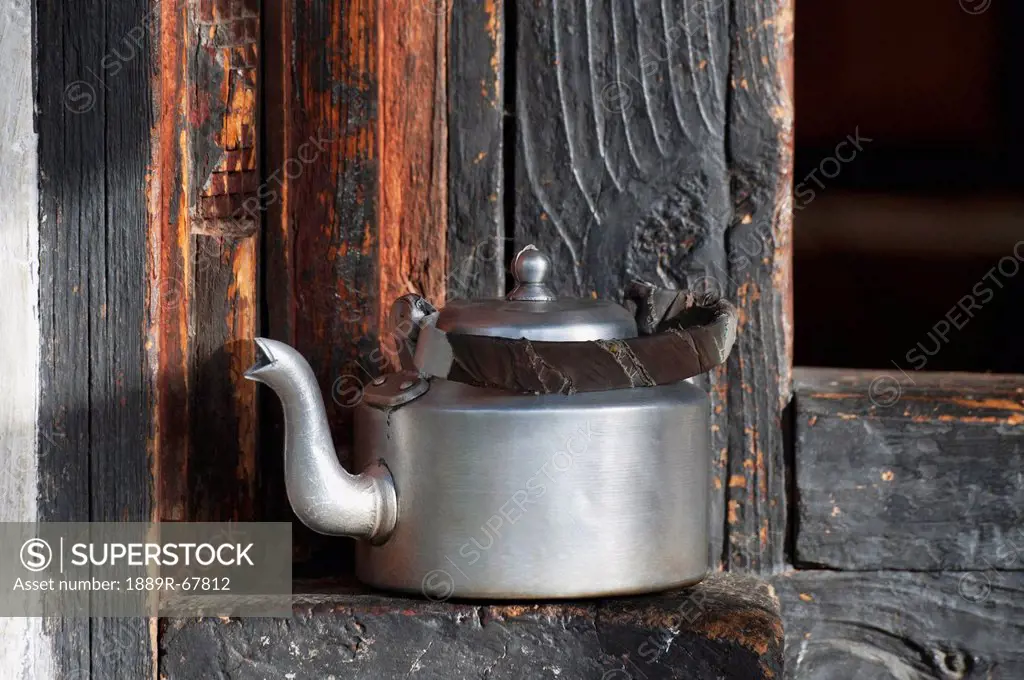 a stainless steel kettle sitting on a wooden ledge, thimphu, thimphu district, bhutan