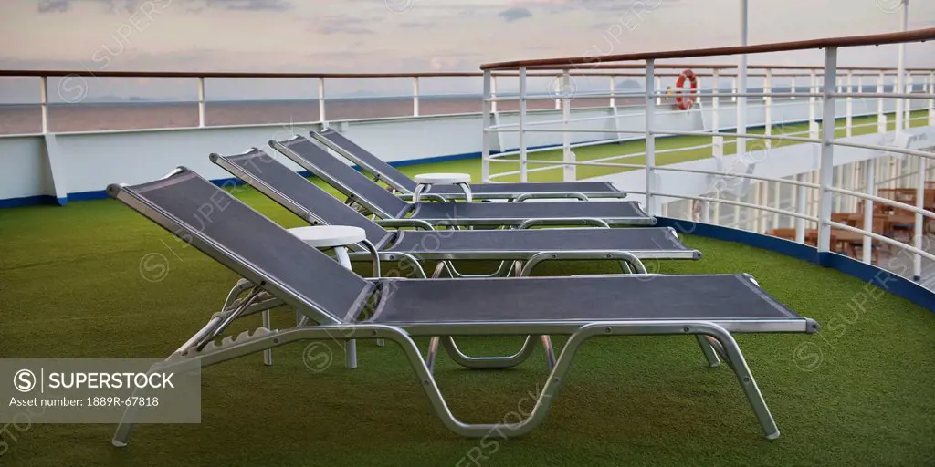 lounge chairs sitting on green artificial turf on the deck of the silver shadow cruise ship