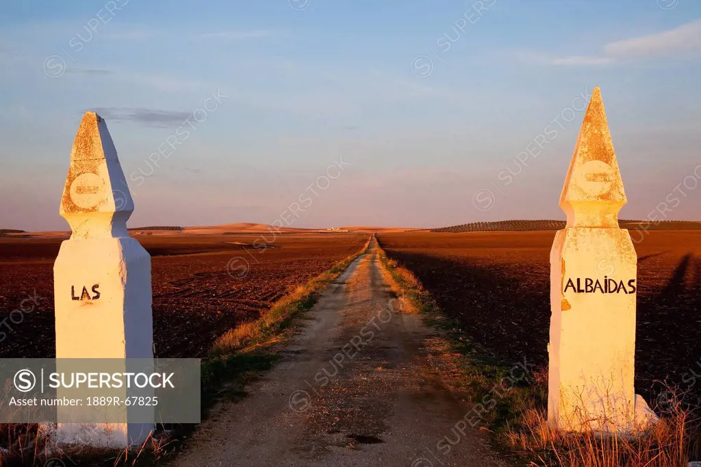 an old road near camoana with two posts on either side saying las and albaidas, andaluaia in spain
