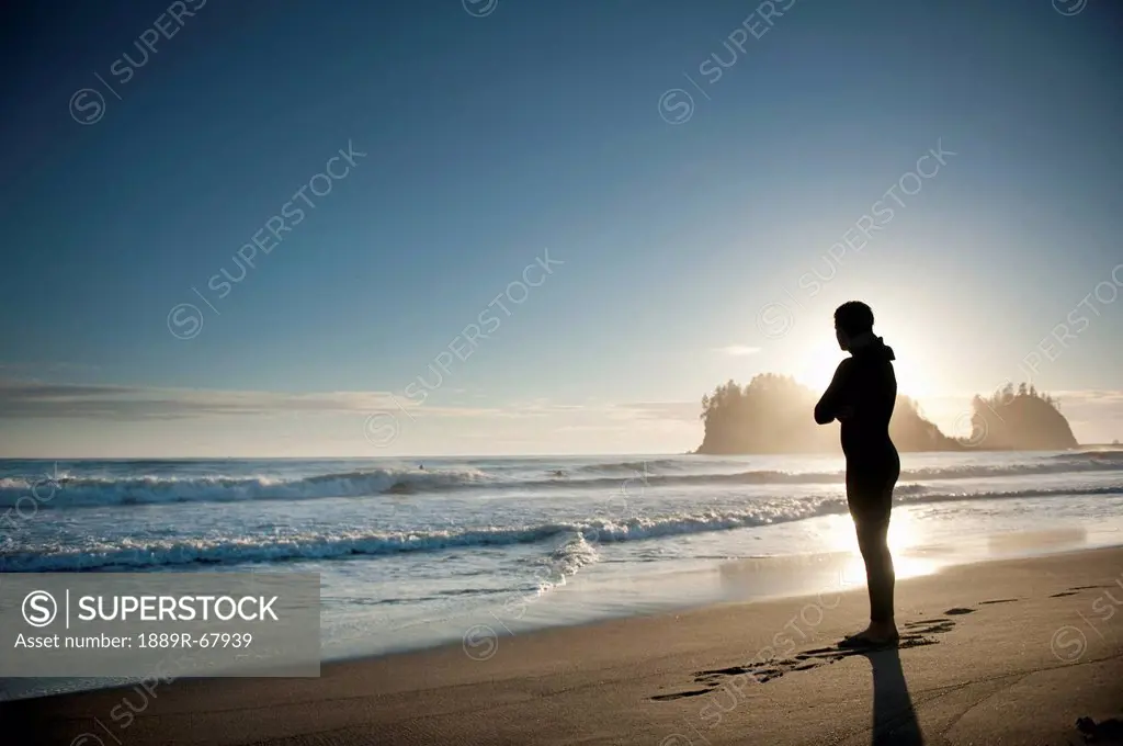 silhouette of a person standing on a beach looking out over the ocean, la push washington united states of america