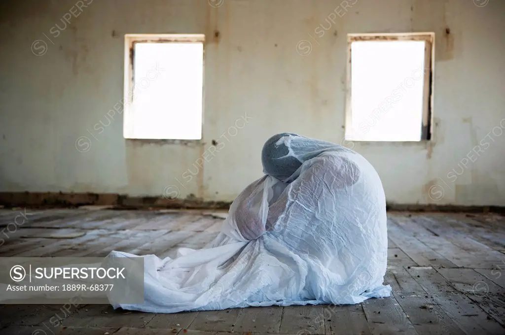 a person wrapped in a blanket in an empty room, south caicos turks and caicos islands