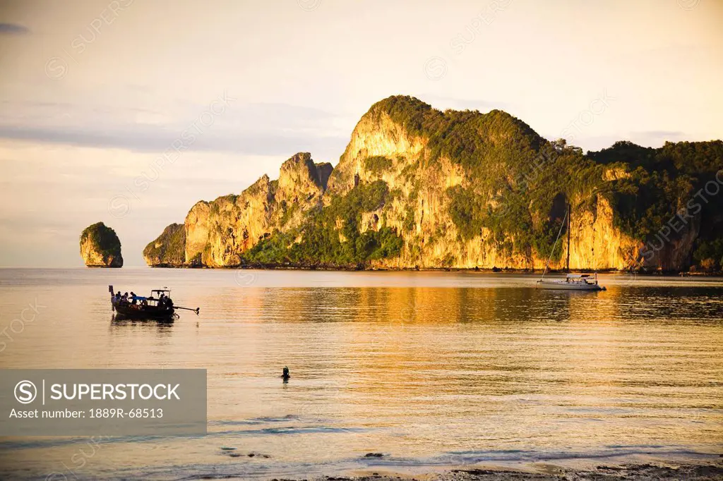 a boat in the water at sunset, phi phi islands thailand