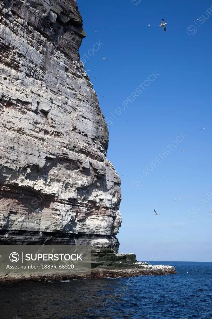 a tall rock face on the water´s edge, noss scotland