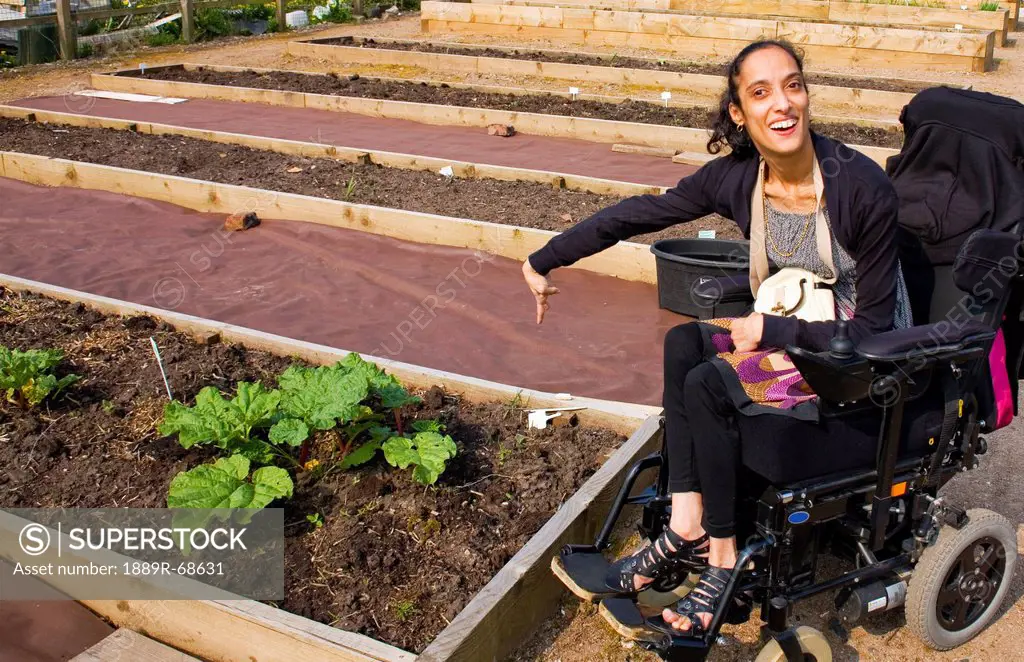 a woman in a wheelchair showing her garden, bolton lancashire england
