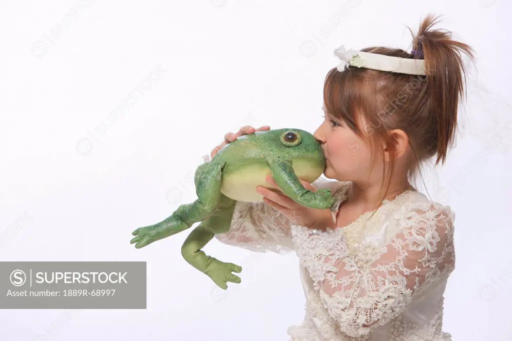 a young girl wearing a princess dress and kissing a green frog, troutdale oregon united states of america
